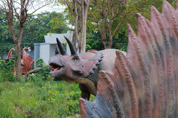 Life-Size Triceratops and Stegosaurus Replicas in a Prehistoric-Themed Park Exhibit © Rifqi Muflih