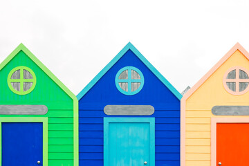 Vibrant Beach Huts, A Colorful Trio of Coastal Charm Against a Bright White Sky