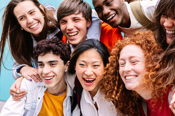 Multiracial group of young high school student friends having fun standing together outdoors
