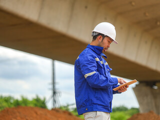 young engineer with the tablet controls the work on site
