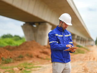 young engineer with the tablet controls the work on site