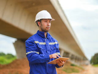 young engineer with the tablet controls the work on site