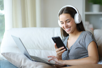 Happy woman using multiple devices on a couch