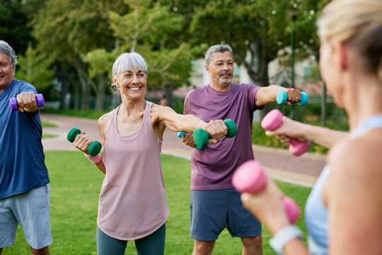 Senior people lifting dumbbells at city park