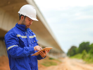 Asian engineer working with tablet at site of a large building project,Thailand people,Work...