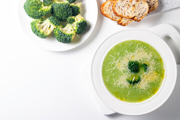 Warm and comforting creamy broccoli soup served in a bowl, garnished with parmesan cheese and...