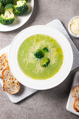Warm and comforting creamy broccoli soup served in a bowl, garnished with parmesan cheese and...