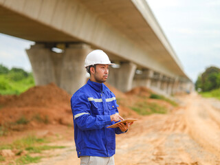 Asian engineer working with tablet at site of a large building project,Thailand people,Work...