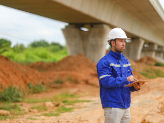 Asian engineer working with tablet at site of a large building project,Thailand people,Work...