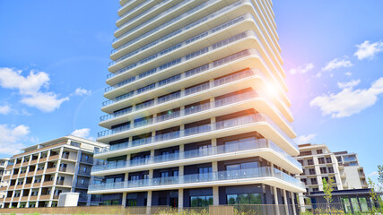 Exterior of a high modern multi-story apartment building - facade, windows and balconies.