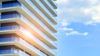 Exterior of a high modern multi-story apartment building - facade, windows and balconies.