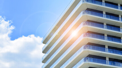 Exterior of a high modern multi-story apartment building - facade, windows and balconies.