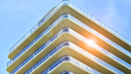 Exterior of a high modern multi-story apartment building - facade, windows and balconies.