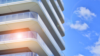 Exterior of a high modern multi-story apartment building - facade, windows and balconies.