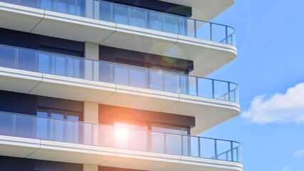 Exterior of a high modern multi-story apartment building - facade, windows and balconies.
