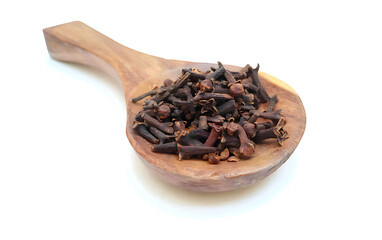 Cloves in a wooden spoon isolated on white background, closeup, herbs and spices