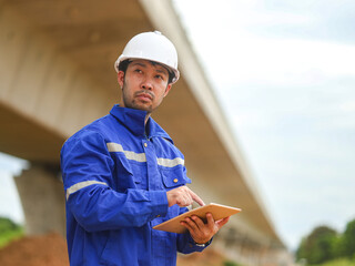 Asian engineer working with tablet at site of a large building project,Thailand people,Work...