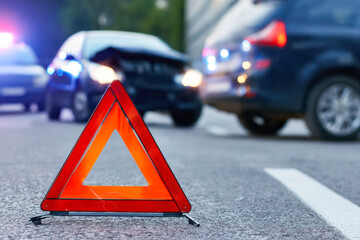 Emergency response at car accident with damaged vehicles and broken glass during night