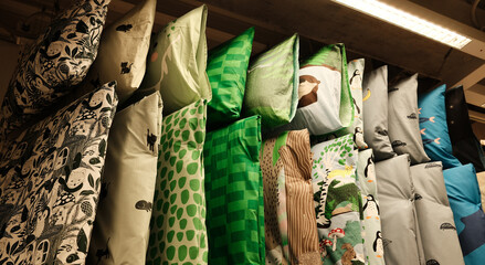 Colorful children's pillowcases with fun animal and nature designs on display in a store, creating...