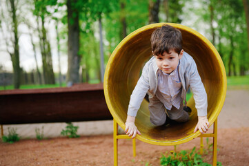 child exploring playground tunnel on sunny day, showcasing adventurous spirit and childhood...