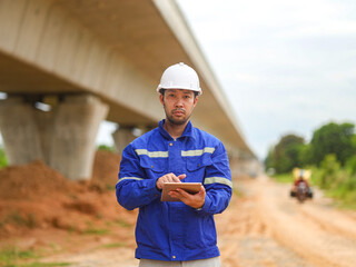 Asian engineer working with tablet at site of a large building project,Thailand people,Work...