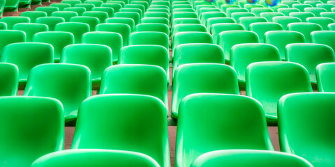 Naklejka premium Vibrant green stadium seats arranged in orderly rows showcasing modern design and bright lighting
