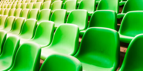 Naklejka premium Rows of vibrant green stadium seats create a modern, orderly design in bright lighting