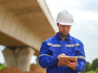 Asian engineer working with tablet at site of a large building project,Thailand people,Work...
