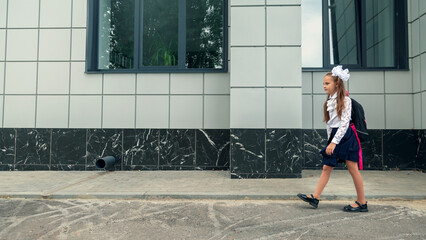 little kid girl with school satchel on first day to school. Back to school concept