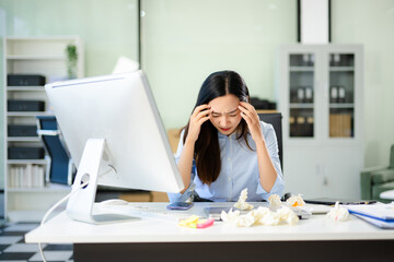 Asian woman feeling migraine head strain.Overworked businesswoman financier while working