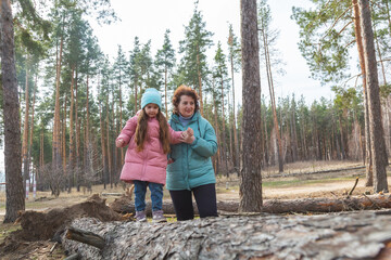 grandmother with granddaughter walking and playing in nature in the forest