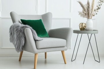 Interior of living room. Gray armchair, green pillow, coffee table and beige wall. Velour Chair against light wall, wooden floor, parquet. Home improvement. Beautiful luxurious modern room settings.