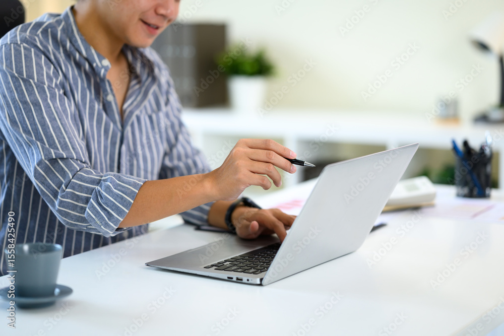 Aufkleber businessman working remotely, analyzing data or making notes on a laptop computer.