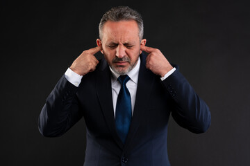 Businessman covering ears in frustration