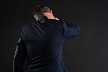 Businessman with neck pain seen from behind