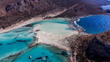 Drone shots of Balos Lagoon capture its breathtaking blend of turquoise waters, white sand, and...