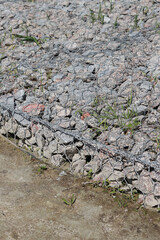 Gabion mattress made of woven mesh with stones for creating paths. Stones in the mesh, creating paths, strengthening. Rubble or crushed stone in a galvanized mesh. Repair in the park