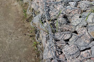 Gabion mattress made of woven mesh with stones for creating paths. Stones in the mesh, creating...