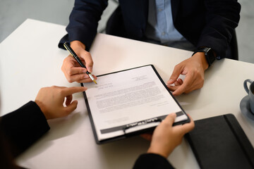 Legal advisor explaining terms of agreement to client before signing contract