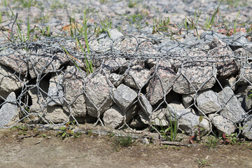 Gabion mattress made of woven mesh with stones for creating paths. Stones in the mesh, creating...
