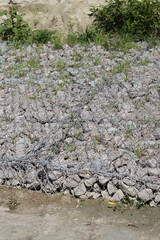 Gabion mattress made of woven mesh with stones for creating paths. Stones in the mesh, creating...