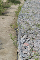 Gabion mattress made of woven mesh with stones for creating paths. Stones in the mesh, creating...
