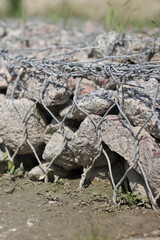 Gabion mattress made of woven mesh with stones for creating paths. Stones in the mesh, creating...