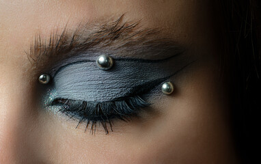 Close-up portrait of young woman with smoky eye makeup.