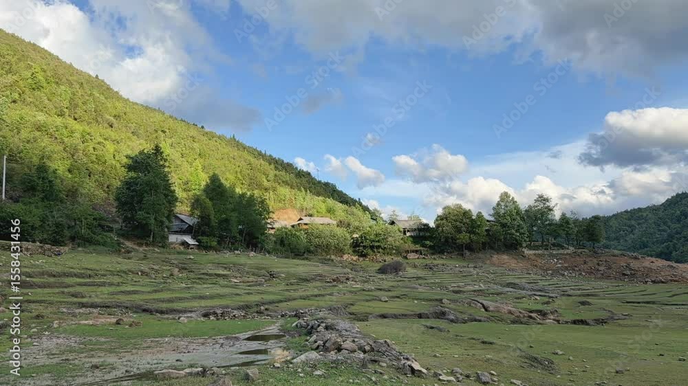 Aufkleber cloud shadows moving swiftly across a forested mountain under a partly cloudy sky. fixed camera capt