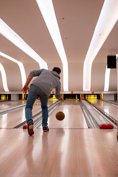 Father playing bowling in modern alley setting