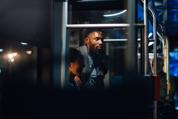 Young basketball player traveling by bus at night looking out the window