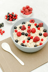 Oatmeal porridge with raspberry,currant berries.Cereal with fruits. Healthy food breakfast,dieting, proper nutrition.Top view flat lay