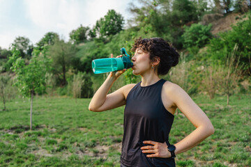 Young woman staying hydrated during outdoor exercise