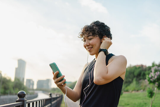 Young woman enjoying music on her smartphone outdoors